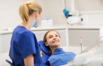 A woman is sitting in a dentist's chair.