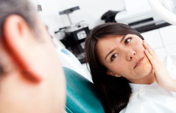 A woman is sitting in a dentist's chair.