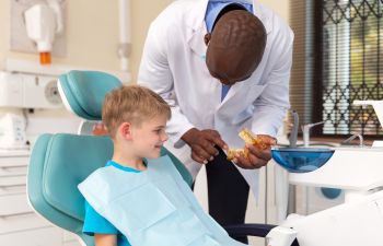 A young boy is sitting in a dentist's chair.