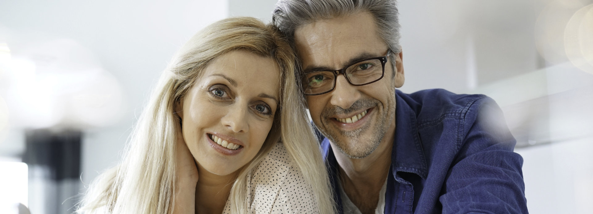 Middle-aged couple with perfect smiles after dental implant treatment