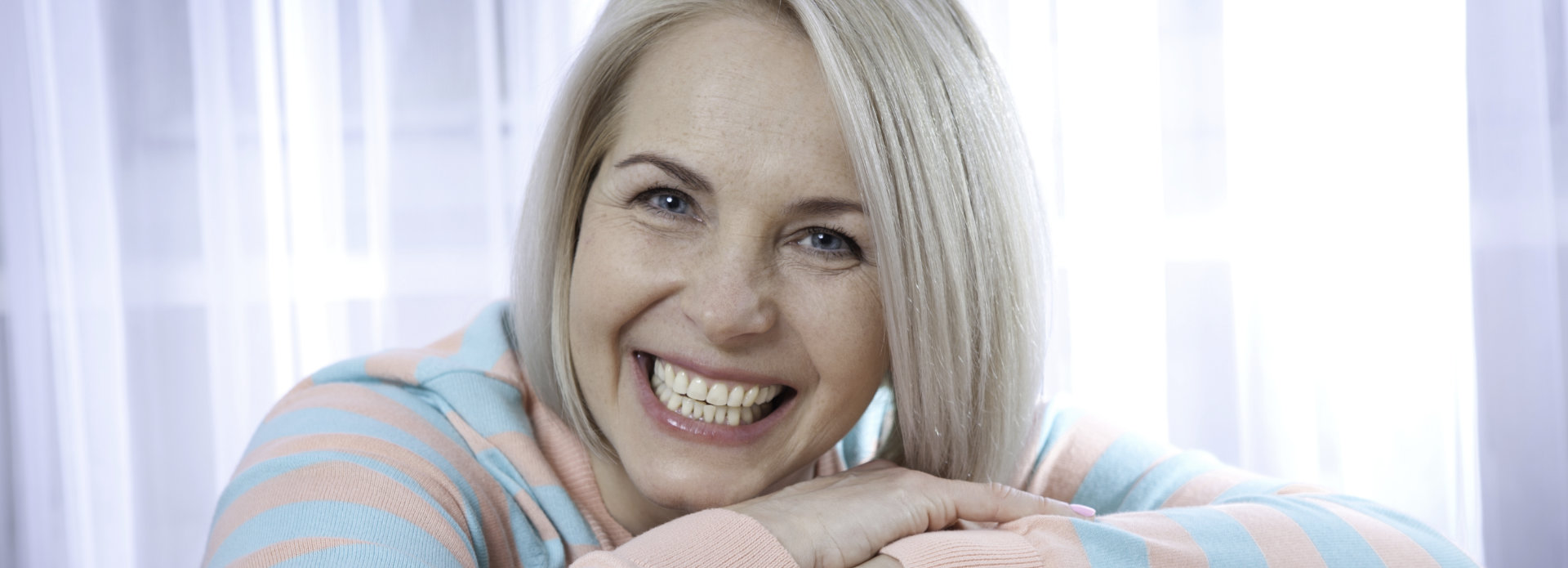happy middle-aged woman showing her beautiful teeth in a smile after dental restorative treatment
