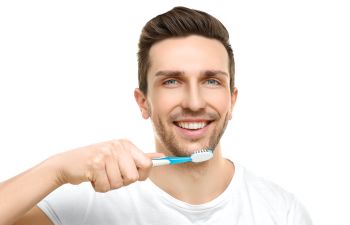 A man is brushing his teeth with a toothbrush.