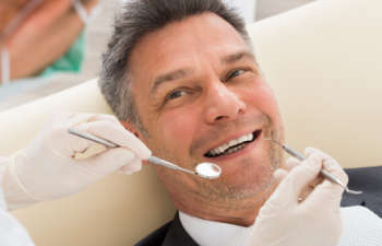 A man is getting his teeth cleaned by a dentist.