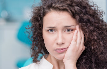 A woman with a toothache in a dentist's office.