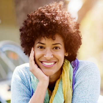 cheerful Afro-American woman leaning her cheek on her hand