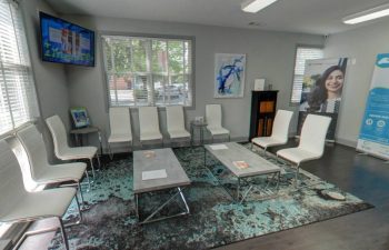 A dental office with chairs and a tv.