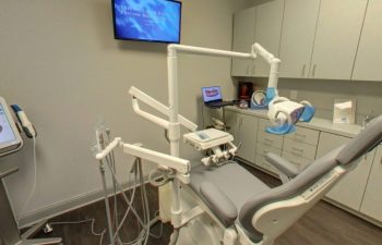 A dental office with a dental chair and a monitor.
