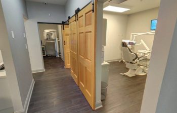 A dentist's office with a door leading to a room.