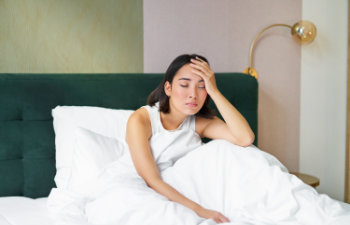 sleepy woman sitting on bed dissatisfied