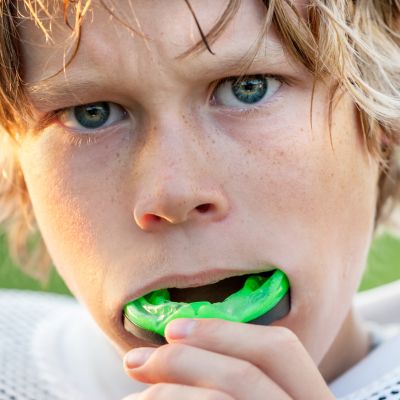 A young athlete inserting mouthguards