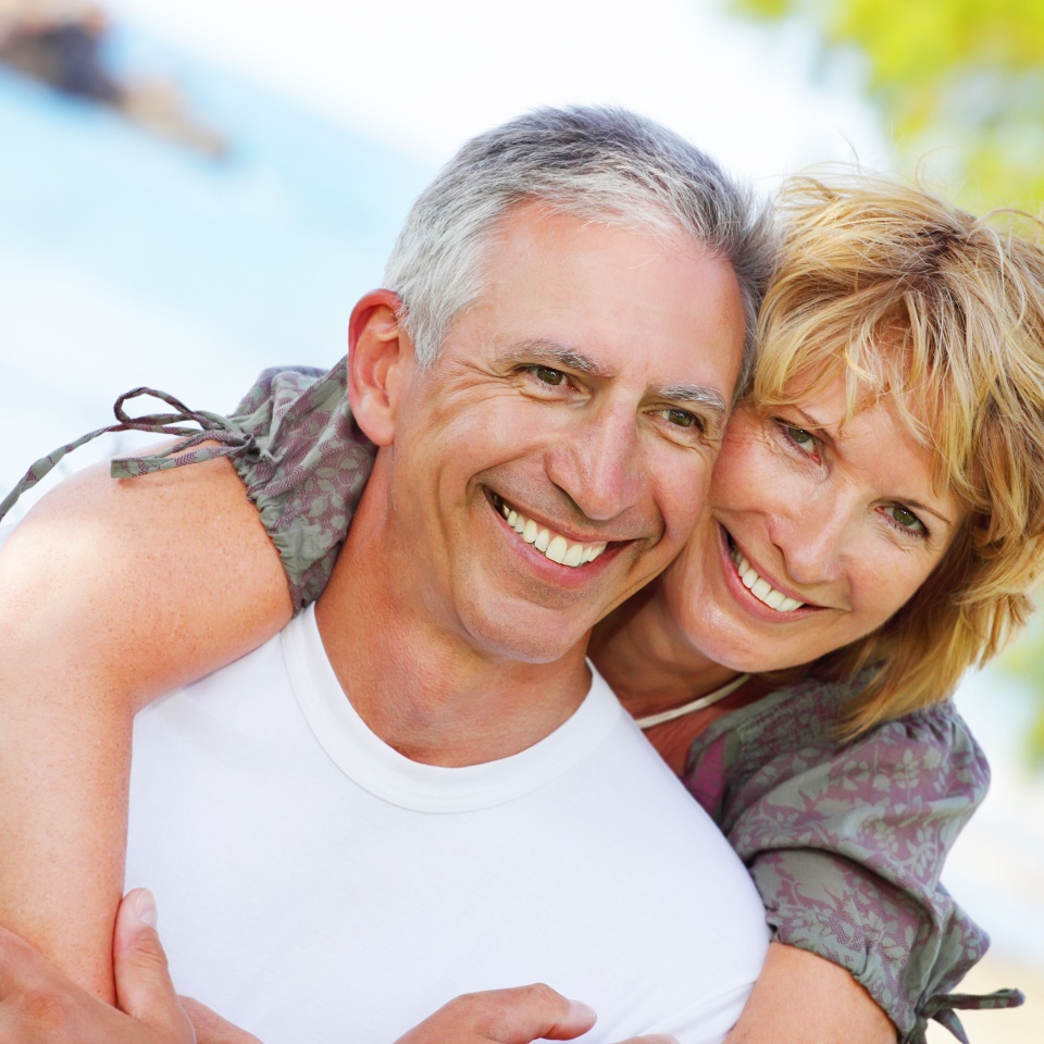 Close-up portrait of a mature couple smiling and embracing.