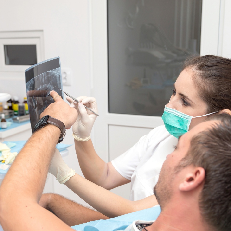Image of young patient and dentist showing him x-ray radiography, in the Dental Clinc