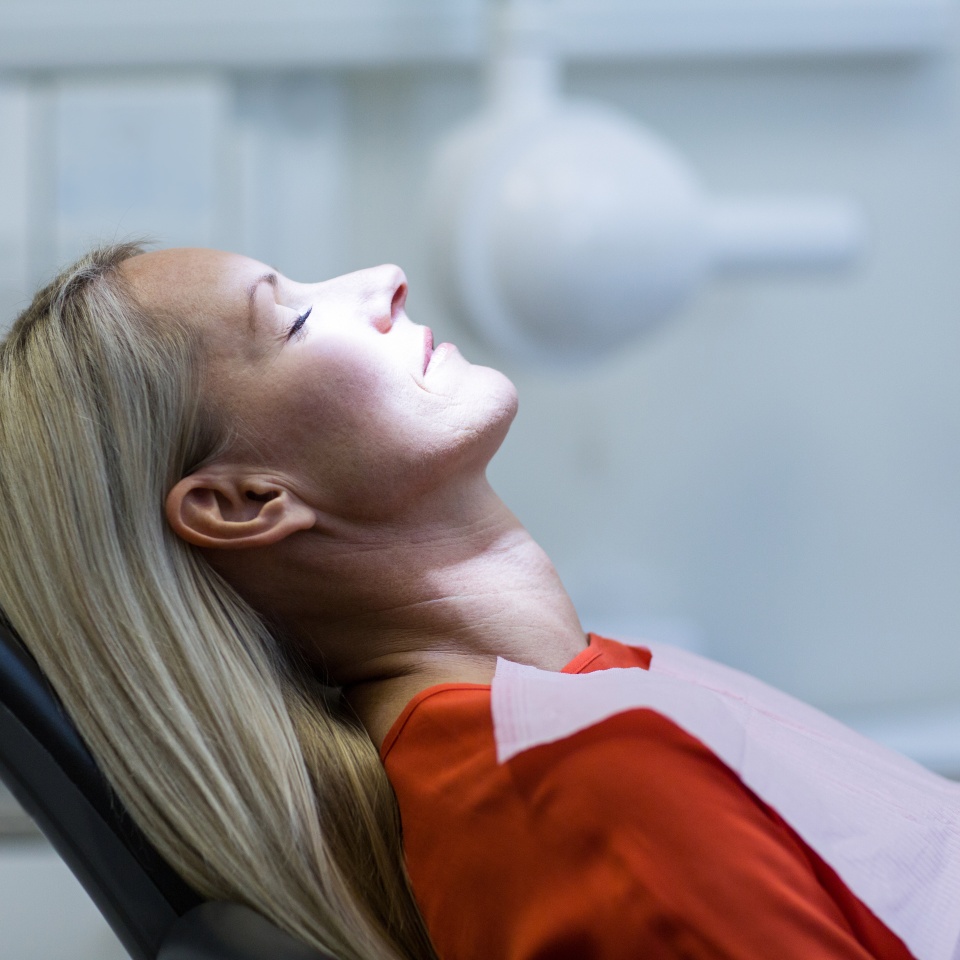 Woman relaxing on dentist chair at dental clinic