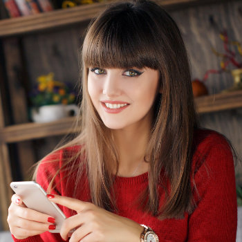 Girl reading SMS on mobile phone Marietta Dental Professionals care