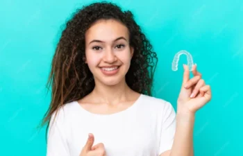 Woman holding Simplyclear Aligners Marietta clear tray smiling