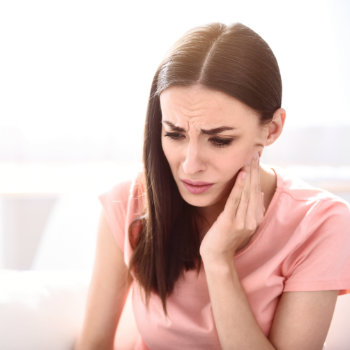 Brunette woman holding cheek tooth pain Emergency Dental Care  Marietta