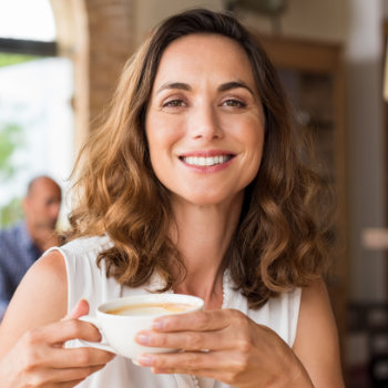 Mature woman smiling holding cup Marietta Dental Professionals care