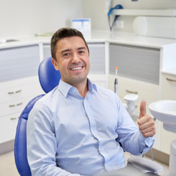Satisfied man thumbs up in chair Marietta Dental Professionals visit