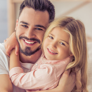 First Smile Pediatric Dentistry father hugging daughter smile