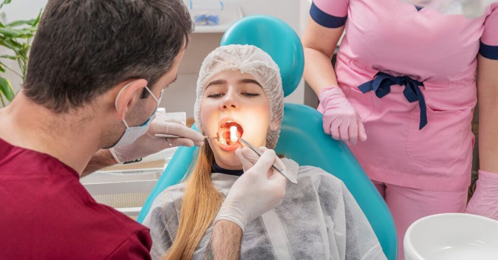Medicare PPO Dentist Dentist and dental assistant performing a professional oral examination on a female patient in a dental clinic